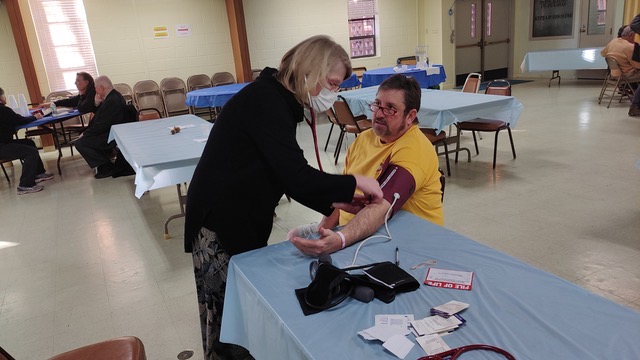 Woman taking a man's blood preasure